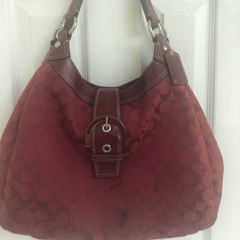 Coach burgundy print shoulder bag with 3 separate compartments.
